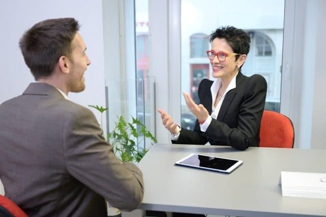 Trainerin und Teilnehmer im Gespräch am Besprechungstisch